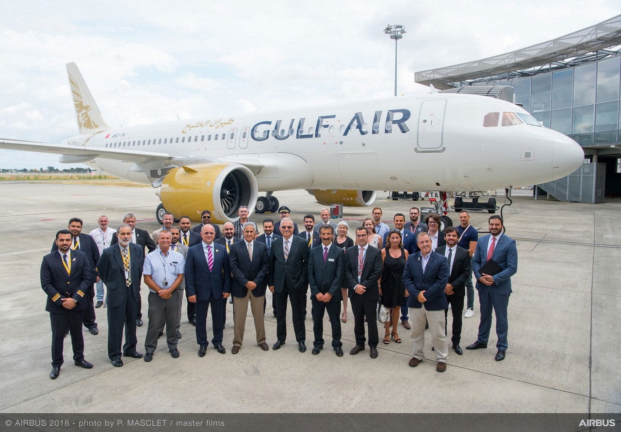 Group of people standing in front of Gulf Air airplane