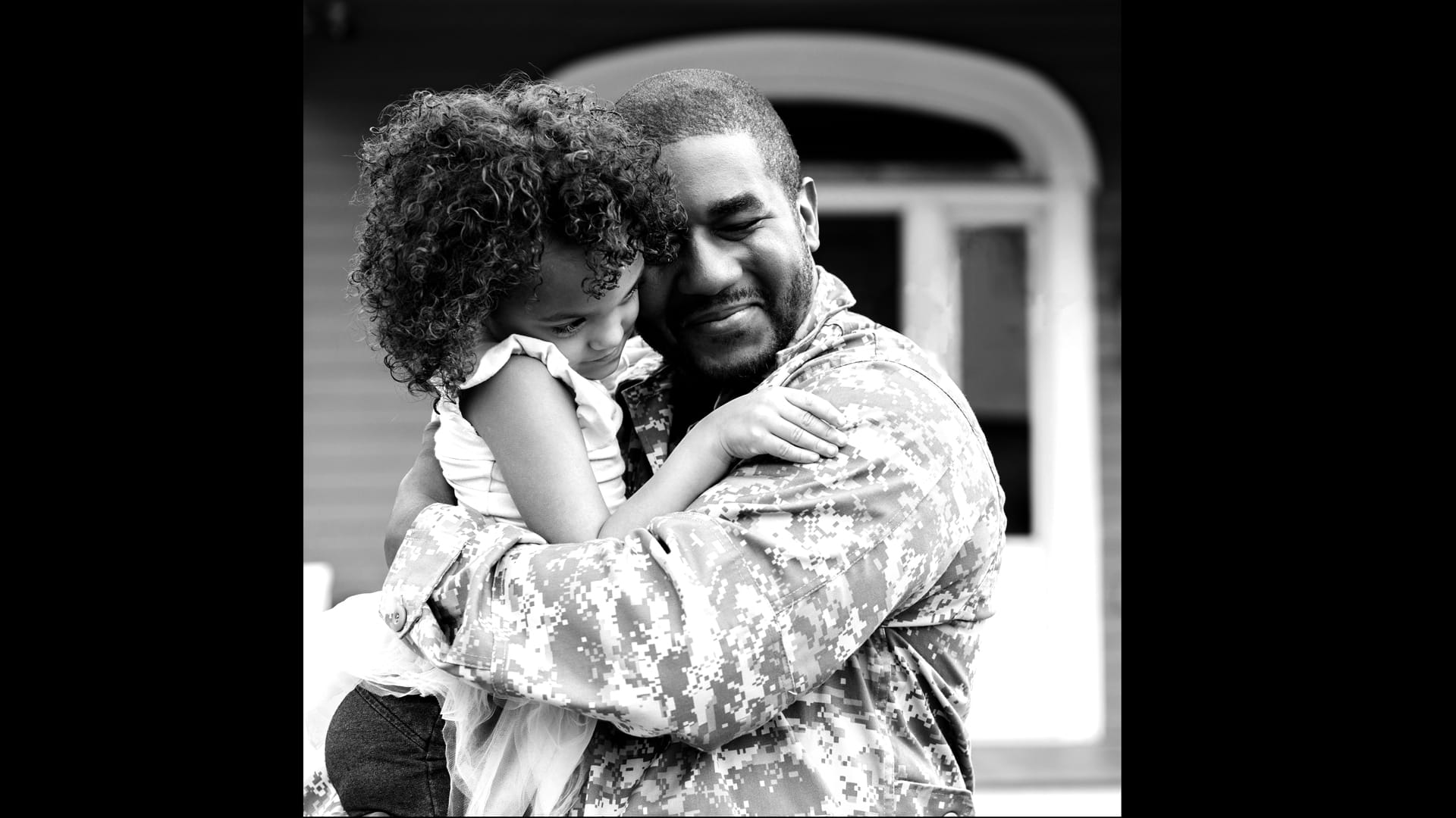 Soldier hugging young girl