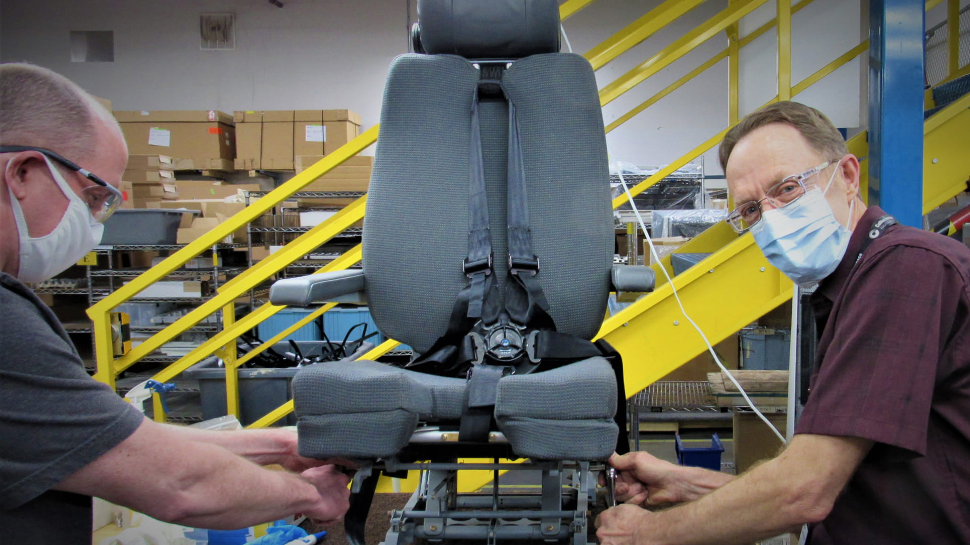 Design engineer, Shawn Day (left) stops to smile while working with Mike Furlong on a pilot seat in the prototyping shop in Colorado Springs, CO.