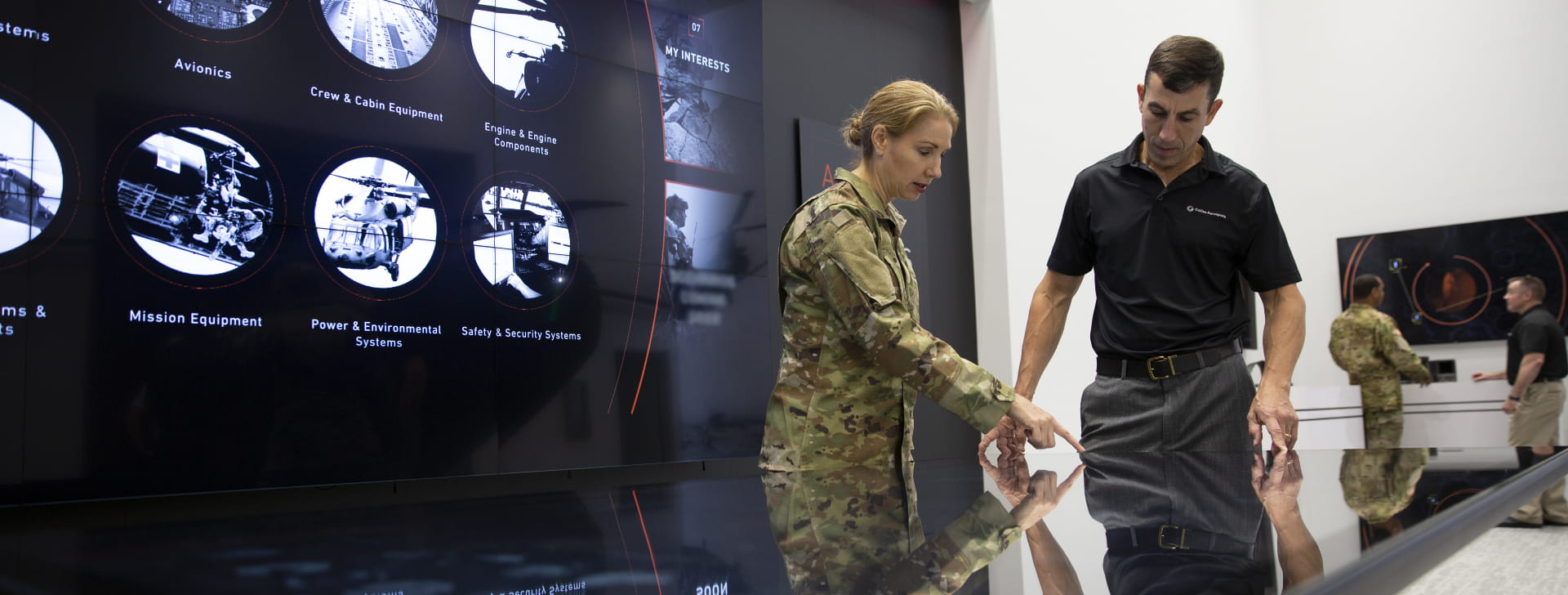 An Army officer conversing with a civilian over an interactive table