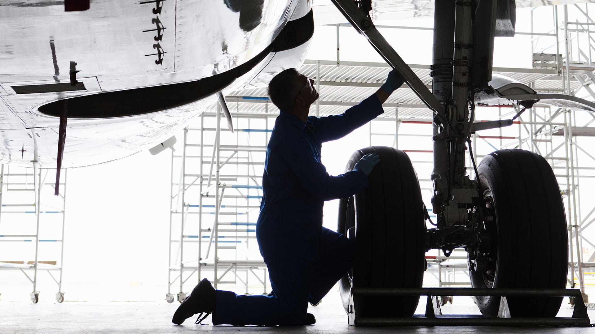 An engineer working on the landing gear of a Boeing 737