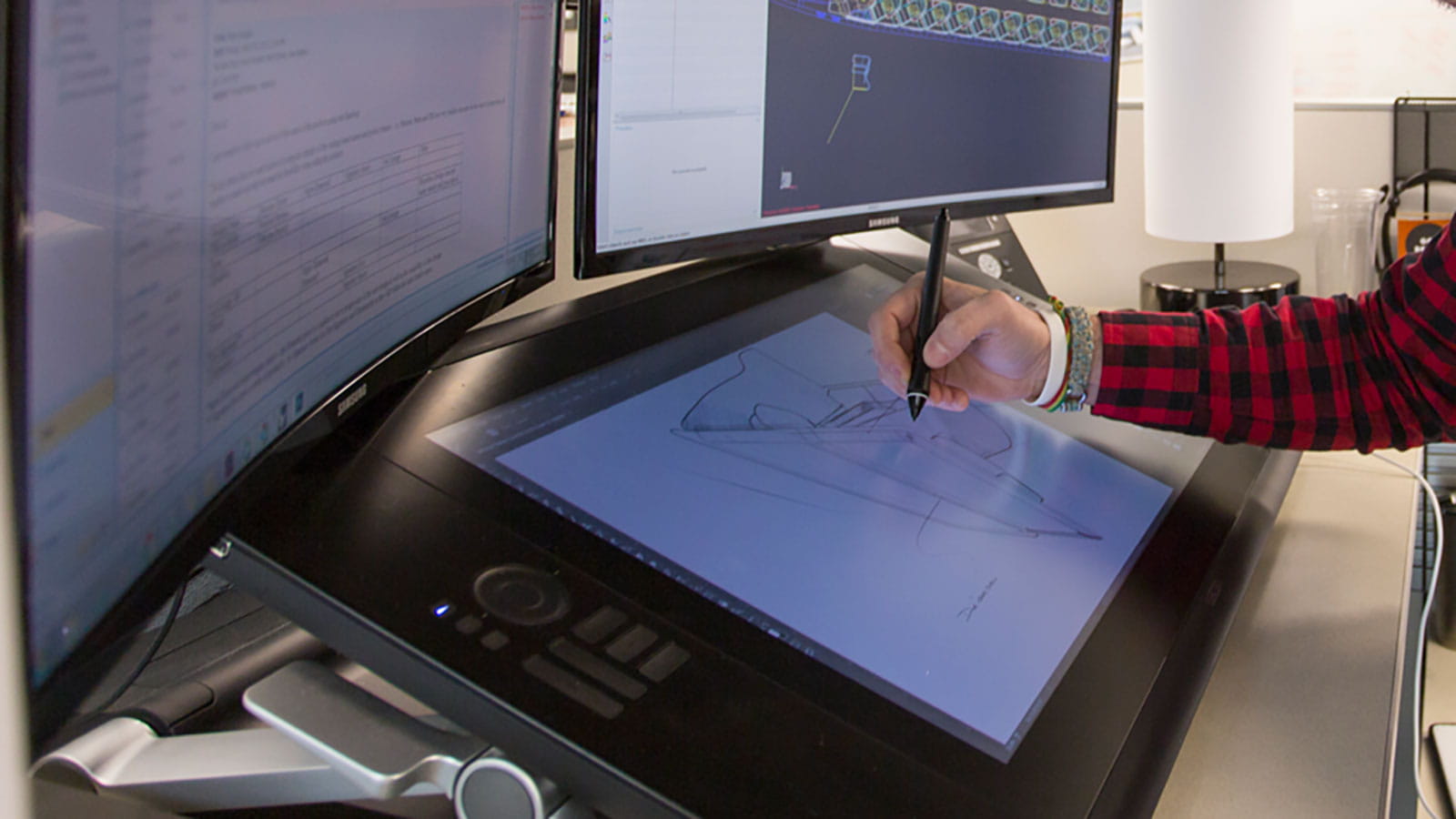 An illustrator works on a large digital tablet