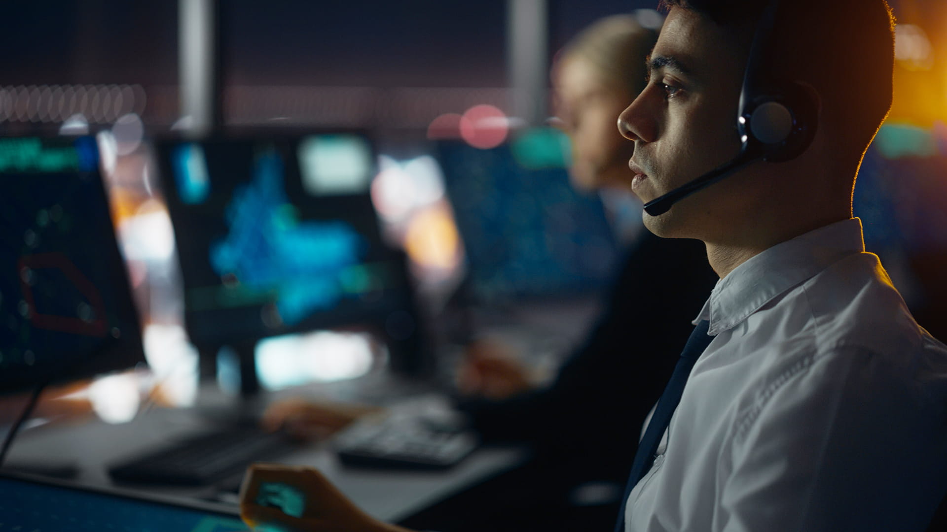 A man with a headset inside of an operations center