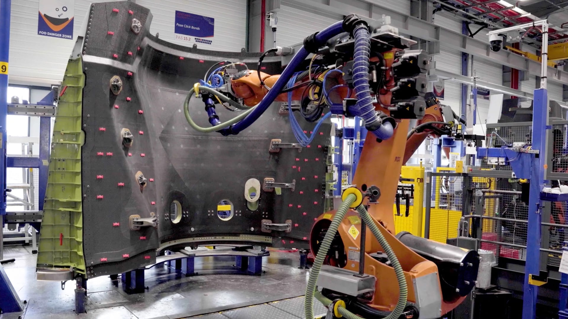 A robot arm performs work on an aircraft component