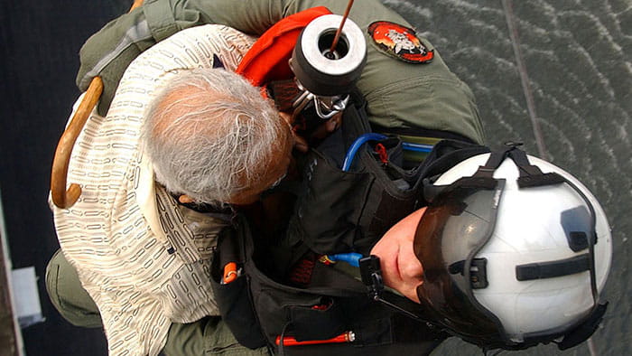 Navy search-and-rescue swimmer rescues an elderly man via rescue hoist during Hurricane Katrina