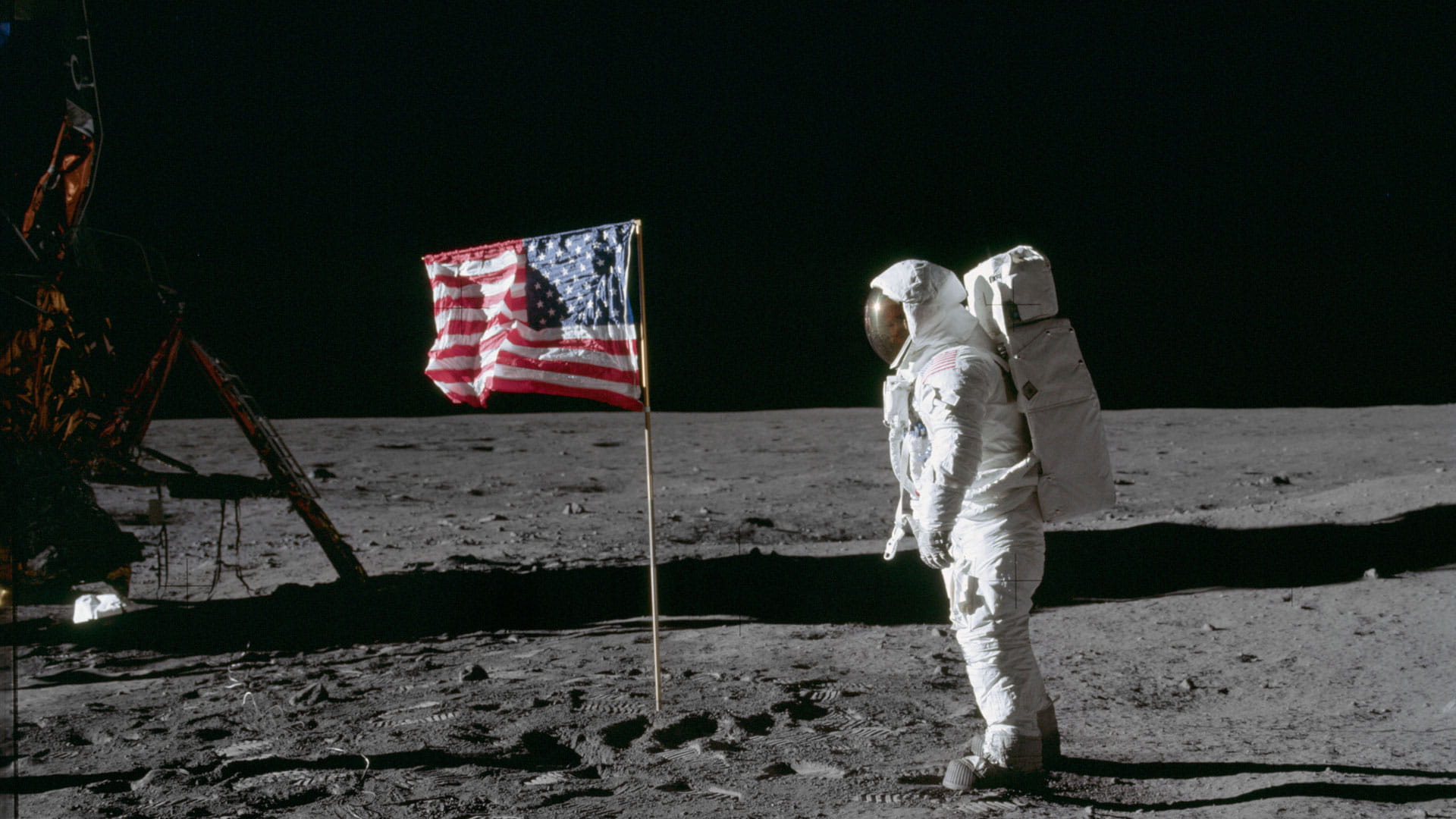 Astronaut on the moon looking at the U.S. flag