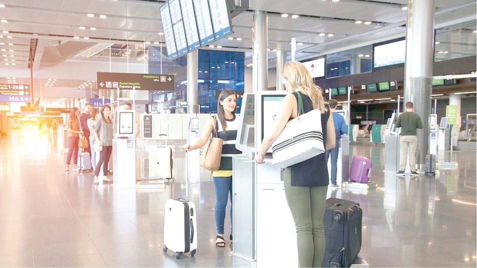 Travelers using airport kiosks