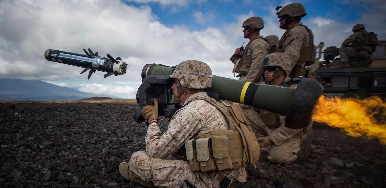 Soldiers watching as another soldier with a shoulder-held launcher deploys a javalin missile