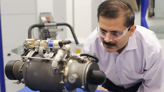 Venkat Vedula, executive director of the Raytheon Technologies Additive PCC, with a small turbojet engine with a 3D-printed main body. 