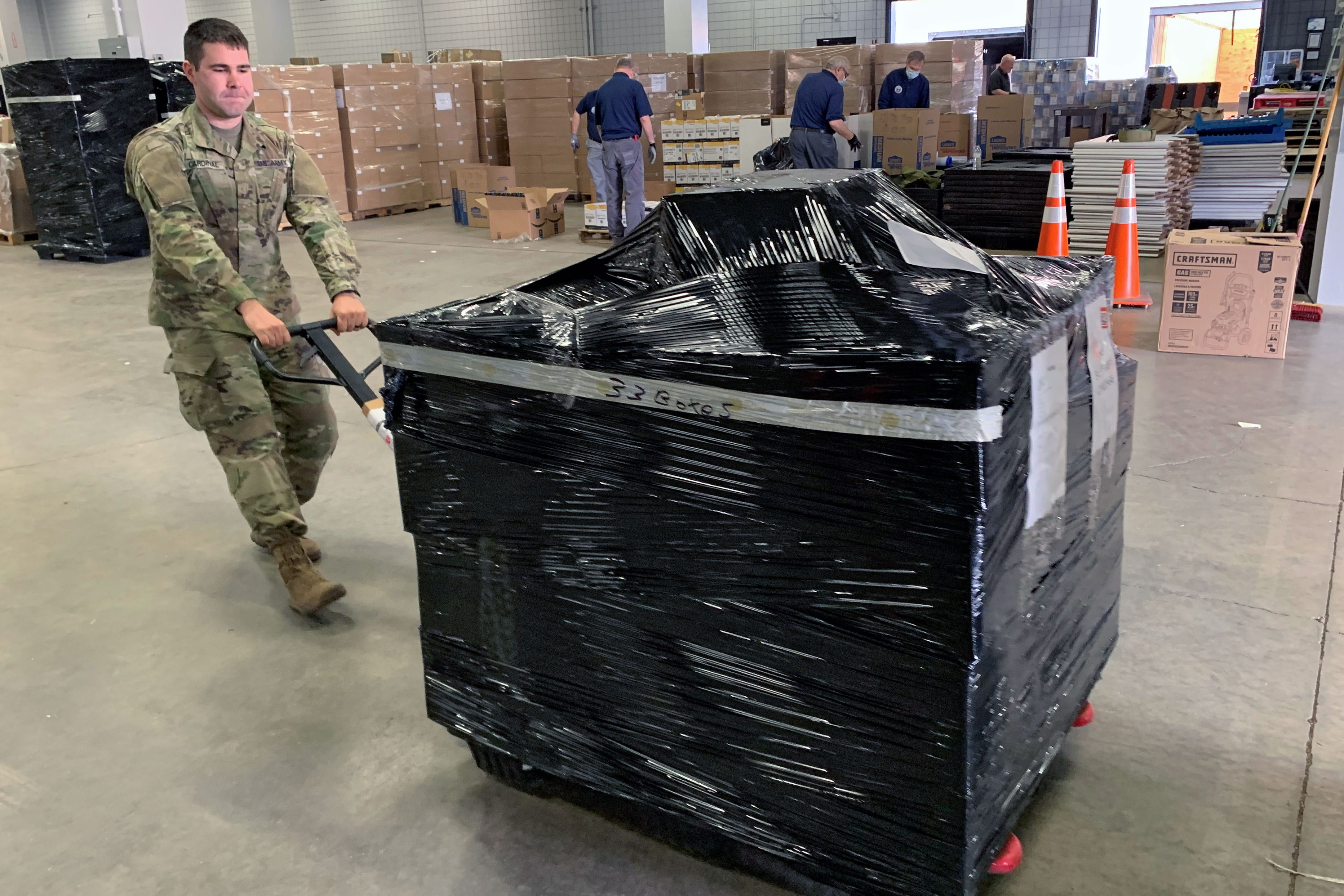 Army 2nd Lt. Jake Cardinal pulls a pallet of latex gloves in a warehouse full of personal protective equipment in Marlborough, Massachusetts. Cardinal’s civilian job is at Raytheon Intelligence & Space; however, after the COVID-19 outbreak, the governor activated Cardinal’s Guard unit. (U.S. Army photo by Spc. Elisamuel Jaime)