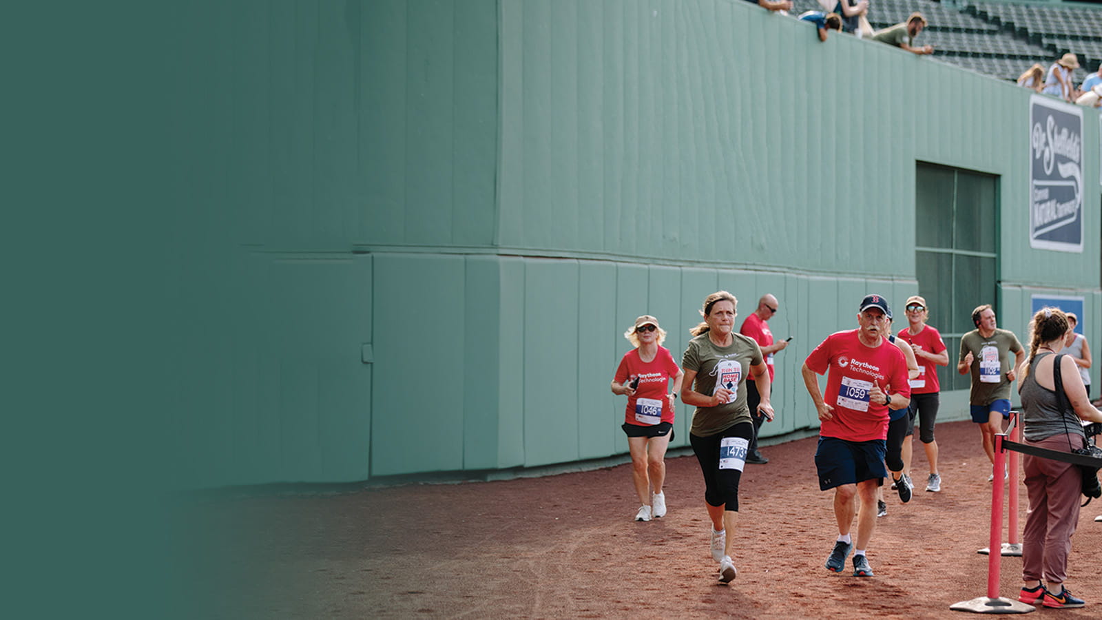 Several runners make a turn on the field at Fenway Park near the finish line of the Run to Home Base 9K event.