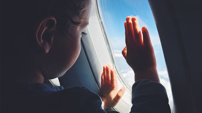 a child looking from a window in airplane