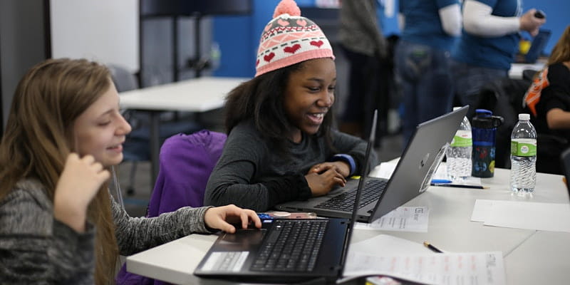 Two elementary-age girls coding on a computer