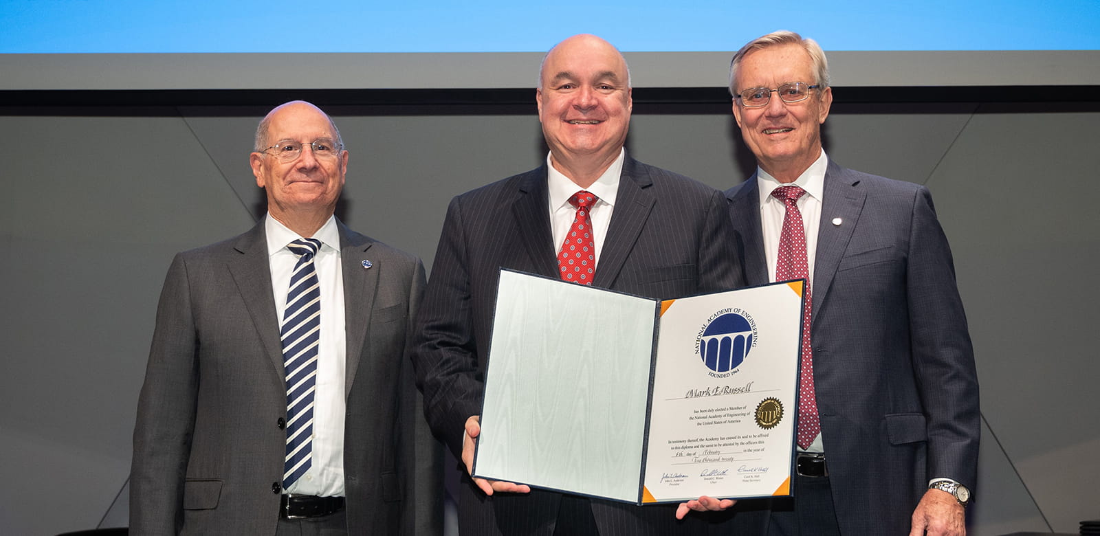 Raytheon Technologies Chief Technology Officer Mark E. Russell, center, attends the National Academy of Engineering induction ceremony. With him, left to right, are academy Chair Donald C. Winter and academy President John L. Anderson.